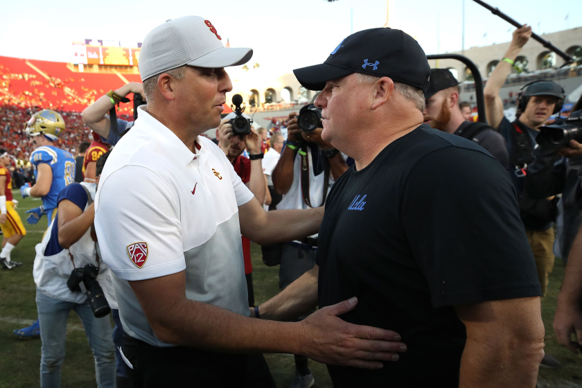 USC coach Clay Helton, left, talks with UCLA coach Chip Kelly after a 52-35 Trojans win Nov. 23, 2019, at the Coliseum.