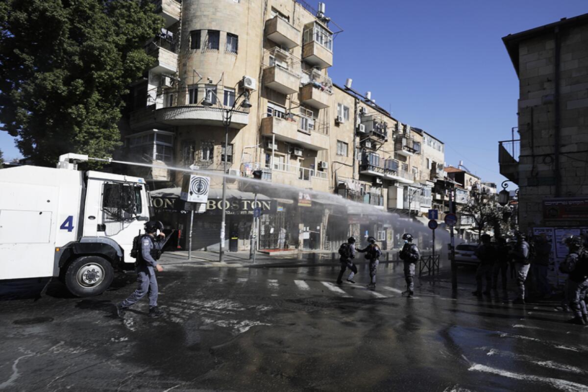 Israeli police use a water cannon to disperse protesters in a Jerusalem neighborhood Sunday.