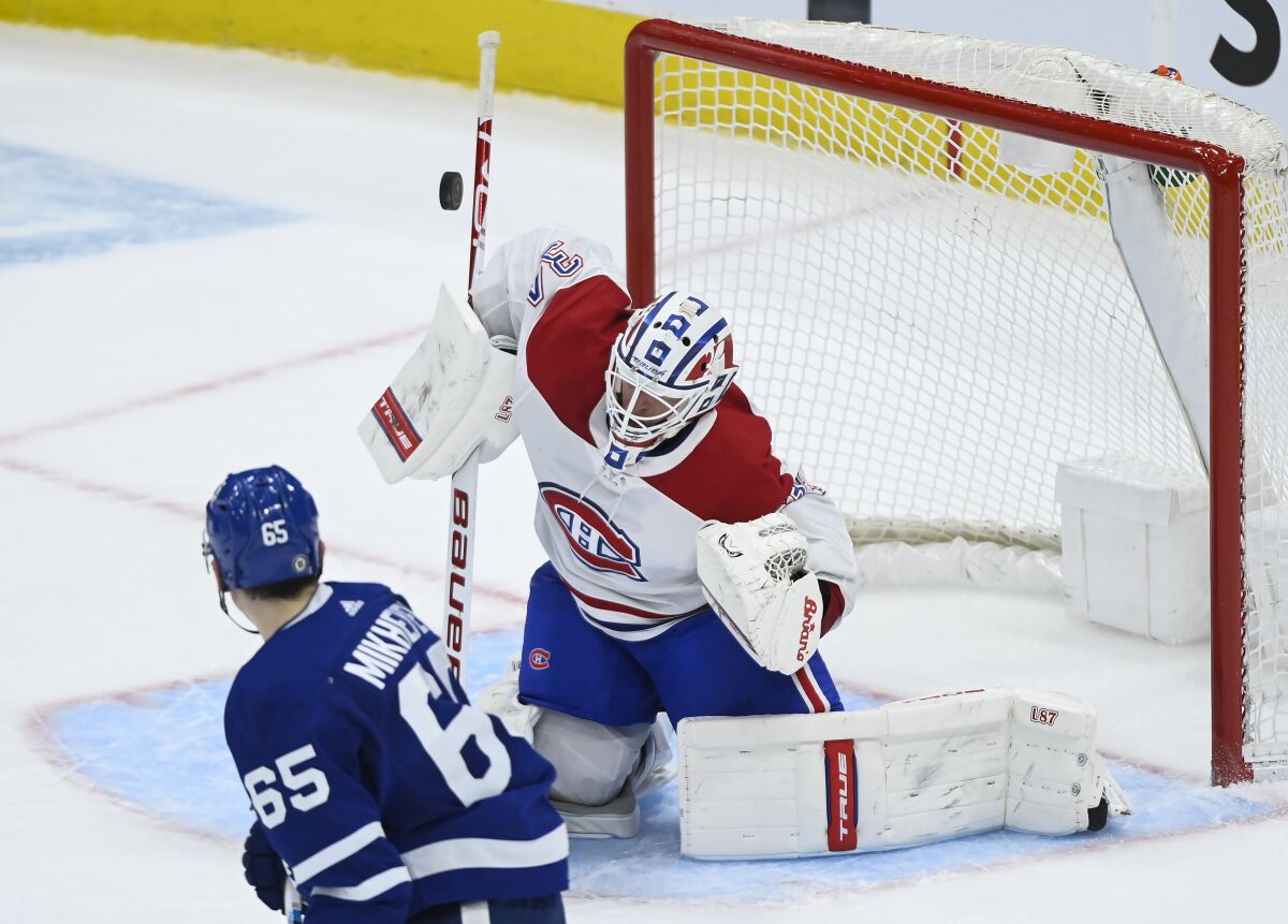 Montreal Canadiens goaltender Jake Allen (34) makes a save as Toronto Maple Leafs forward Ilya Mikheyev (65) looks for the rebound during the second period of an NHL hockey game Saturday, May 8, 2021, in Toronto. (Nathan Denette/The Canadian Press via AP)