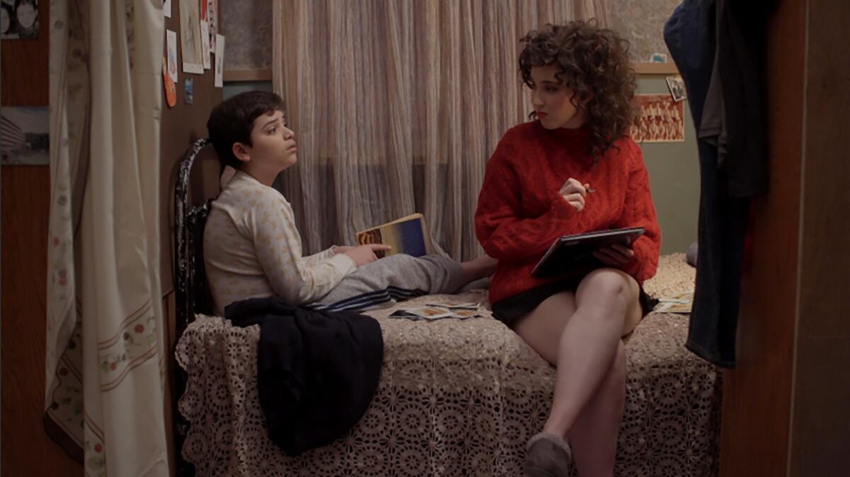 A young boy and his mother sit on a bed in the movie "Potato Dreams of America."