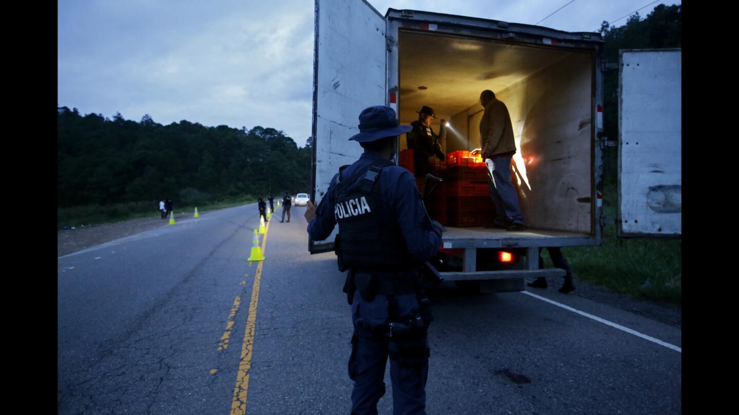 Honduran national police inspect a delivery truck at a checkpoint on a highway near Ocotepeque, Honduras, a few miles from the Guatemala border. The agents are attempting to reduce the number of unaccompanied children traveling to the U.S.; no children were found on this truck.