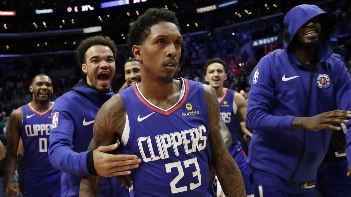 Lou Williams is mobbed by teammates after making the game-winning shot as time expired Sunday against the Brooklyn Nets at Staples Center.