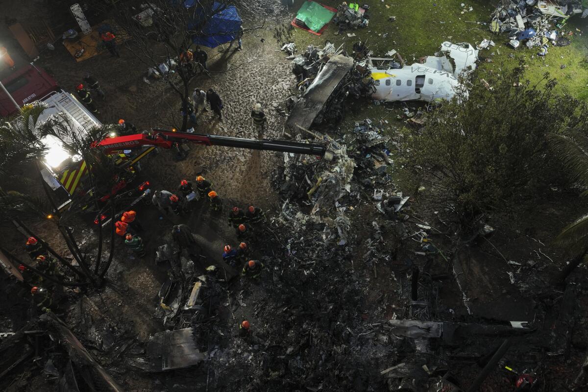 Firefighters and rescue workers amid the debris of a passenger plane crash.