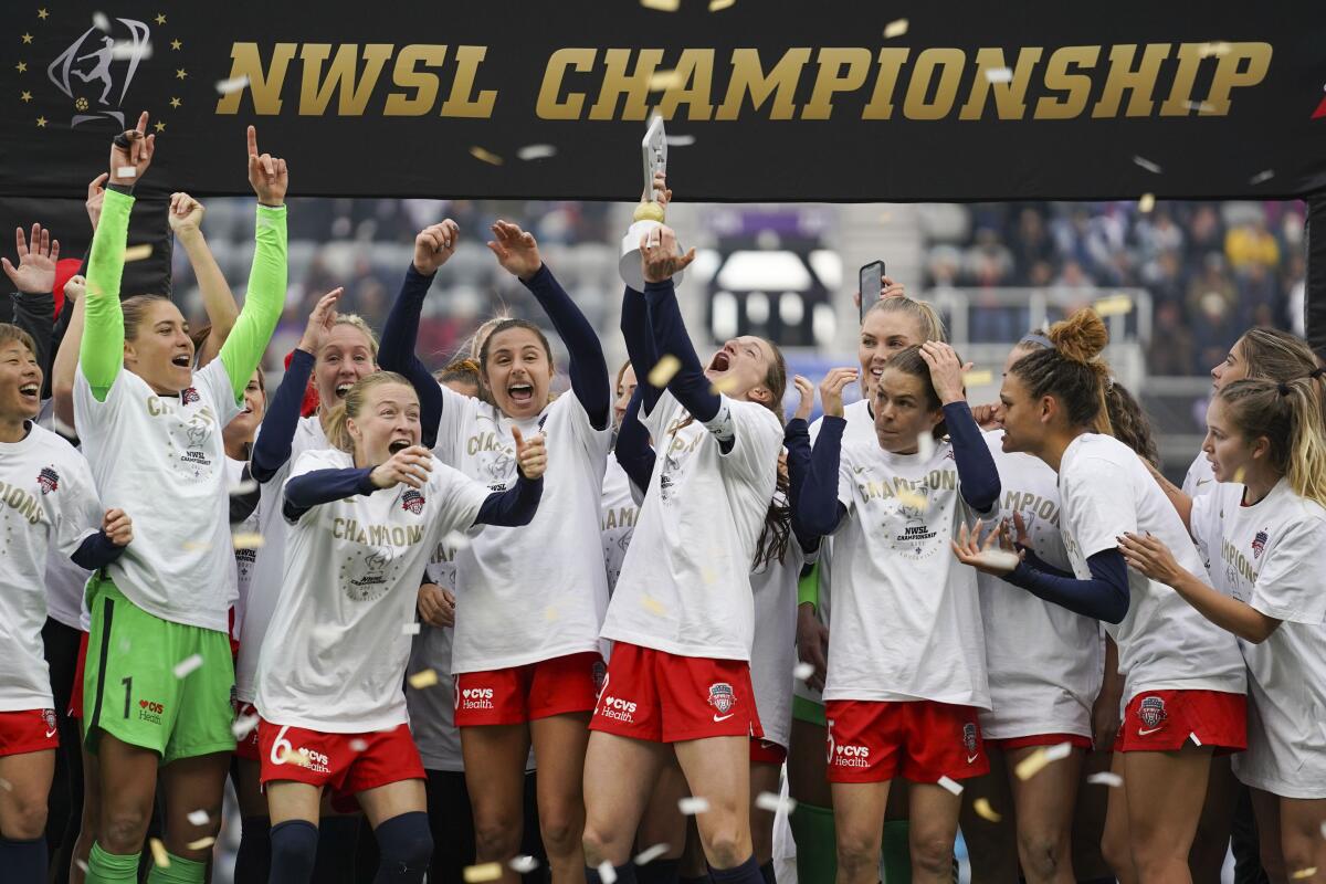 Washington Spirit's Andi Sullivan, center, lifts the trophy as they celebrate after defeating the Chicago Red Stars.