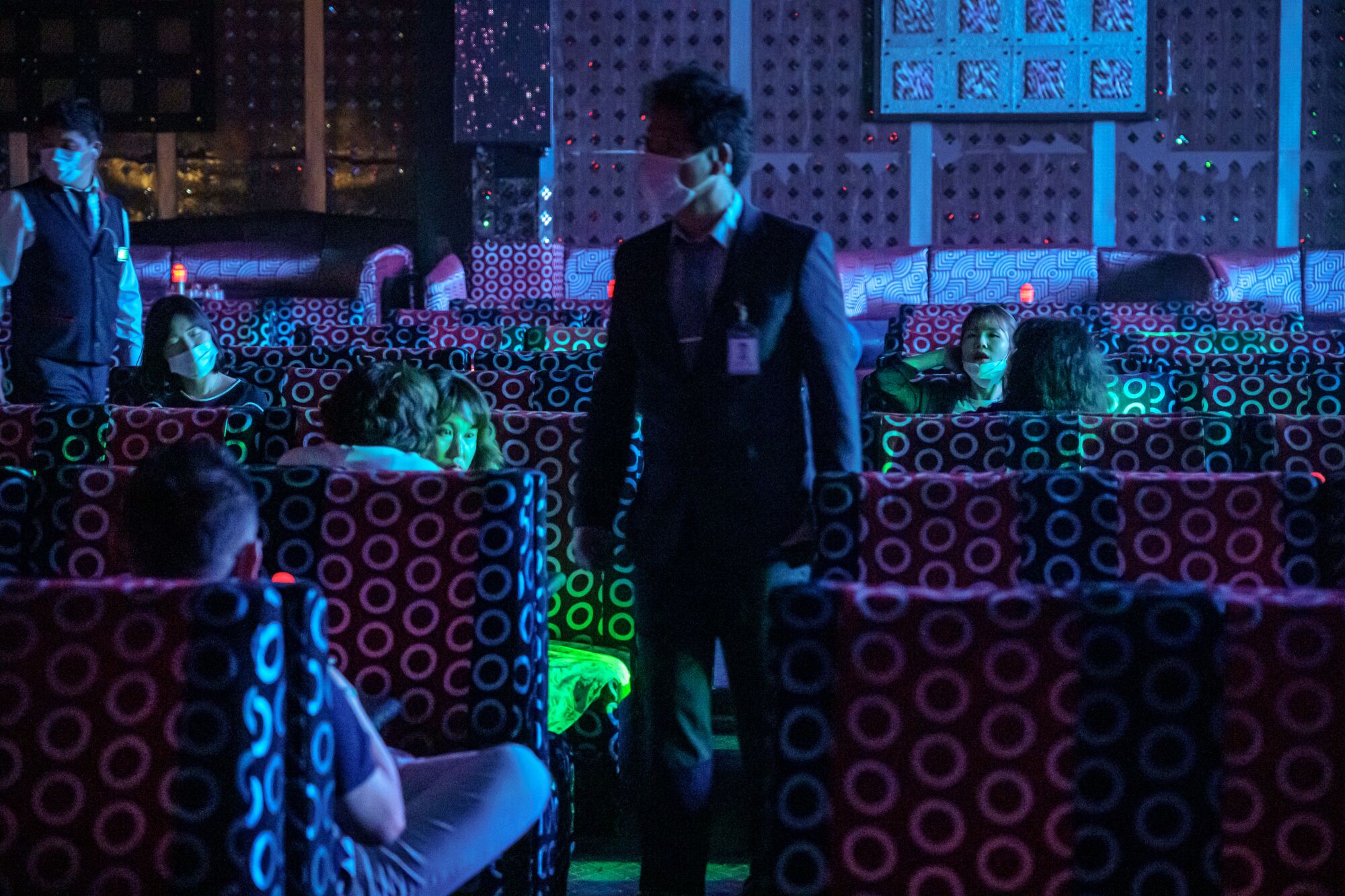A server walks through the sparsely occupied nightclub in South Korea.