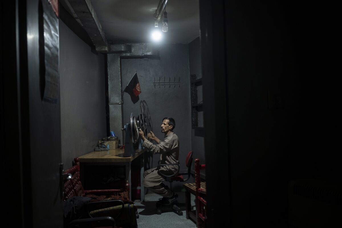 Movie projectionist playing back a film roll