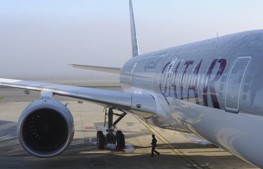 A person walks near one of the two Airbus A350-900 aircrafts for the Qatar Airways company on December 22, 2014 at the Airbus Group center in Toulouse, southern France. The CEO of Qatar accused three major airlines of attacking his carrier because they can't compete with the service it offers.