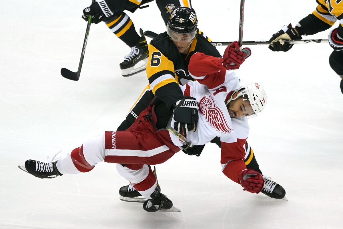 Pittsburgh Penguins' John Marino (6) collides with Detroit Red Wings' Robby Fabbri (14) during the first period of a preseason NHL hockey game in Pittsburgh, Sunday, Oct. 3, 2021. (AP Photo/Gene J. Puskar)