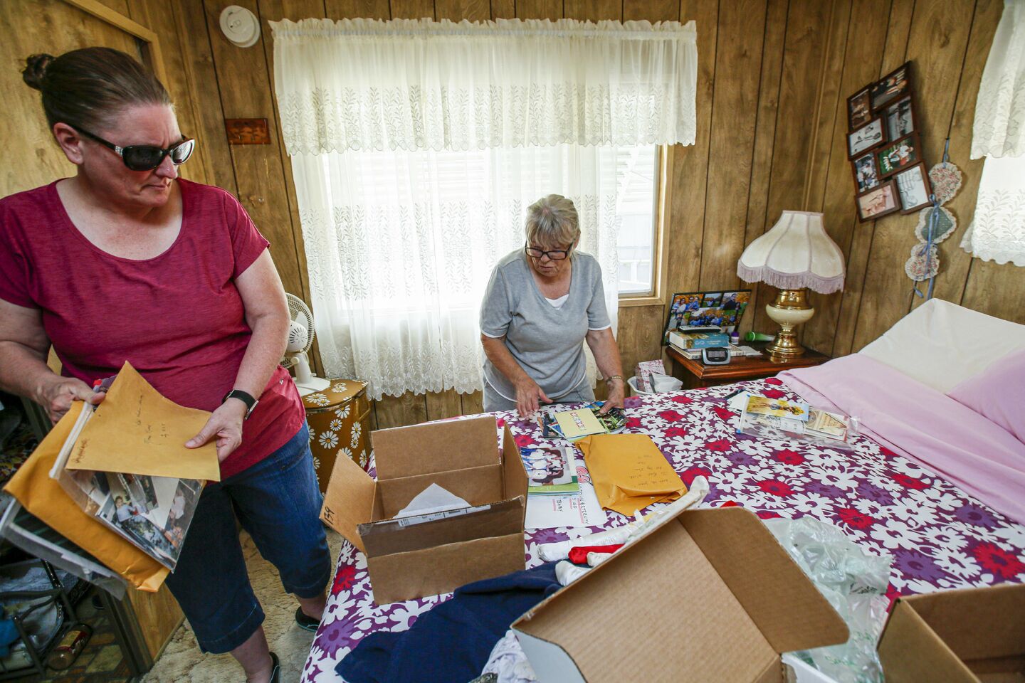 Susan Manson, 53, left, helps her mother Charlotte Sturgeon, 78, retrieve photos and important documents from Sturgeon's red-tagged mobile home at Torusdale Estates on Ward Avenue in Ridgecrest.