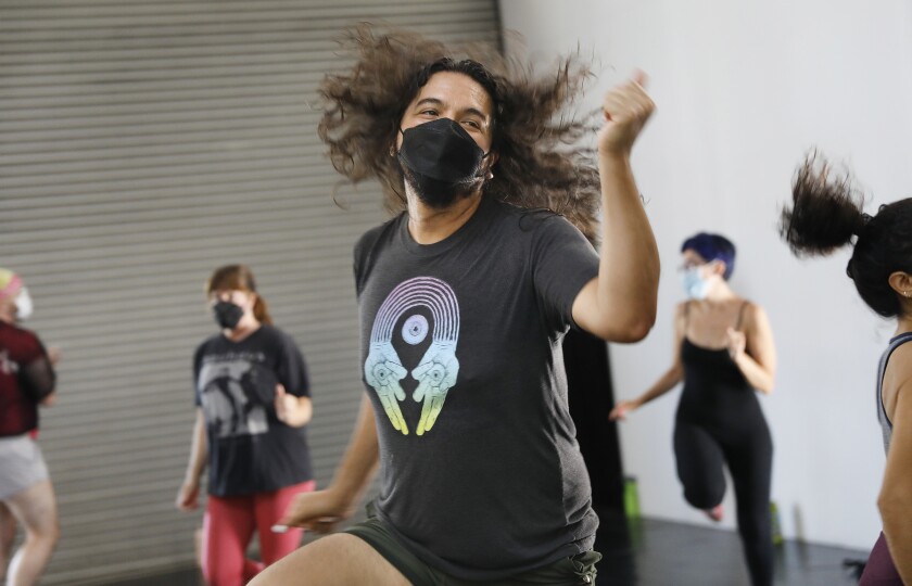  A person's long hair flies while doing aerobic dance moves. 