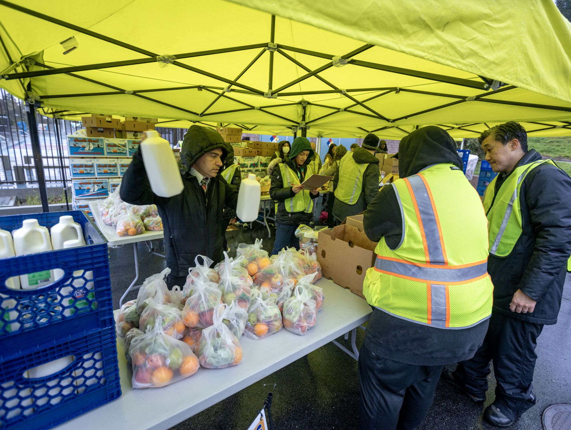 Los trabajadores distribuyen comidas para los estudiantes en un sitio para llevar 