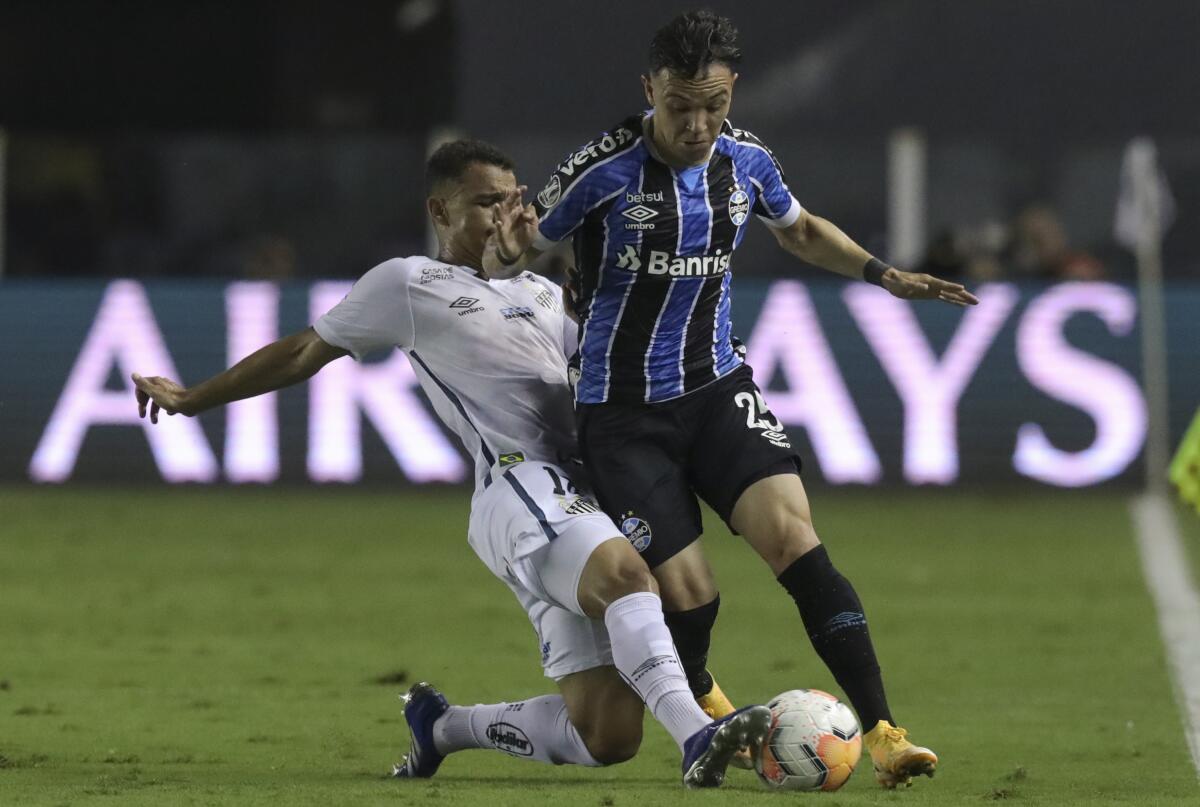Pepe of Brazil's Gremio, right, and Renyer of Brazil's Santos battle for the ball during a Copa Libertadores quarterfinal second leg soccer match in Santos, Brazil, Wednesday, Dec. 16, 2020. (Amanda Perobelli/Pool via AP)