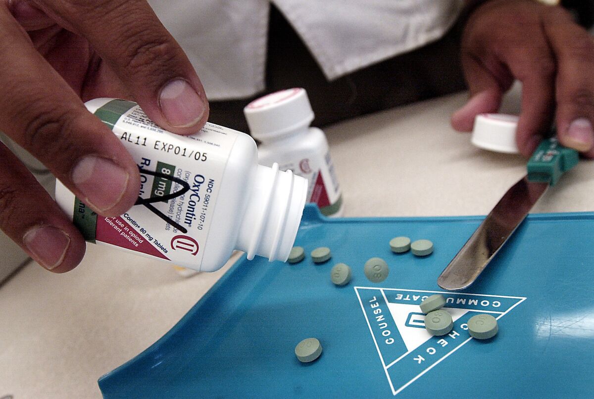 A pharmacist displays tablets of the prescription painkiller OxyContin. A new study finds that 91% of people who had a nonfatal overdose of opioid painkillers like OxyContin continue to get refills from a doctor.