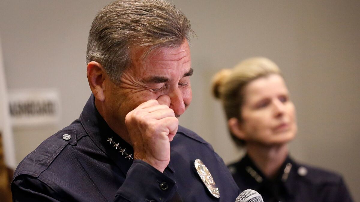 LAPD Chief Charlie Beck wipes away a tear at a Friday news conference, where he announced he would step down in June.