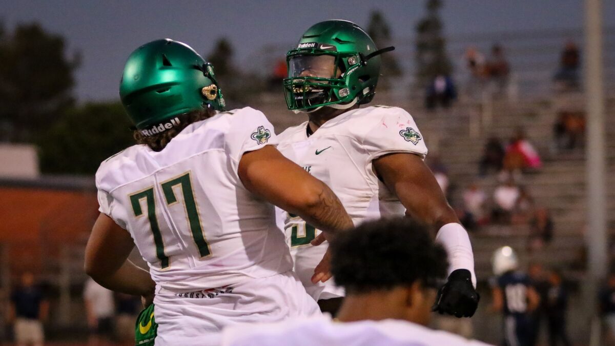 Jordan Banks bumps chests with Narbonne teammate Ikani Tuiono just before kickoff against St. Paul on Sept. 6. 