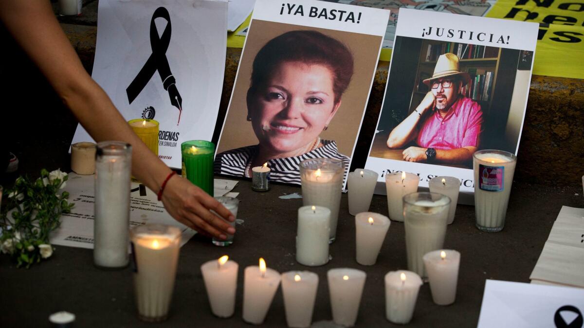 A woman places a candle in front of pictures of victims during a demonstration against the killing of journalists, outside the Interior Ministry in Mexico City in May. Another journalist, Gumaro Perez, was killed in Mexico on Tuesday.