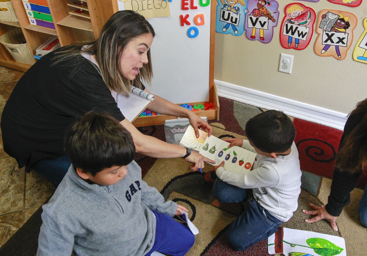 La especialista en apoyo a la calidad de YMCA Childcare Resource Service, Marlene Fuentes, trabaja con niños 