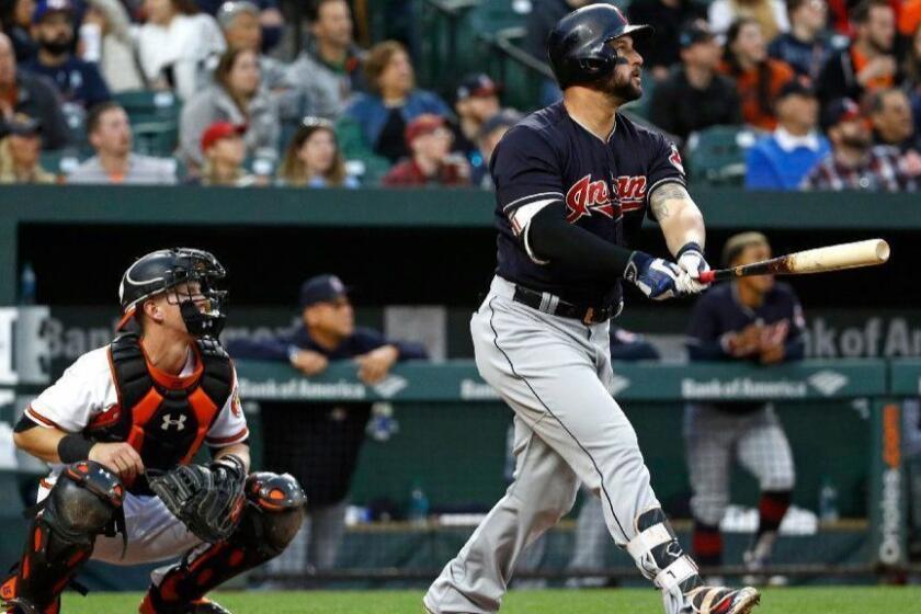 Cleveland Indians' Yonder Alonso, right, watches his two-run home run in front of Baltimore Orioles catcher Chance Sisco in the second inning of a baseball game, Monday, April 23, 2018, in Baltimore. (AP Photo/Patrick Semansky)
