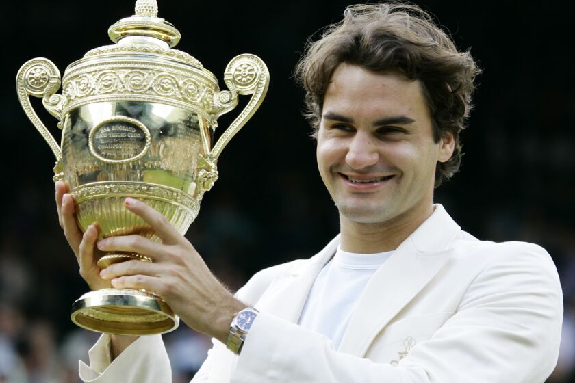 FILE - Roger Federer holds the winners trophy after his 6-0, 7-6, 6-7, 6-3 victory over Spain's Rafael Nadal in the men's singles final at Wimbledon, Sunday July 9, 2006. Roger Federer knows a thing or two — or 20 — about making one's way to a Grand Slam championship. Now the retired tennis star can help you find your way around town. Waze said Wednesday, May 31, 2023, that Federer's voice will be available to provide directions for drivers using the navigation app. (AP Photo/Anja Niedringhaus, File)