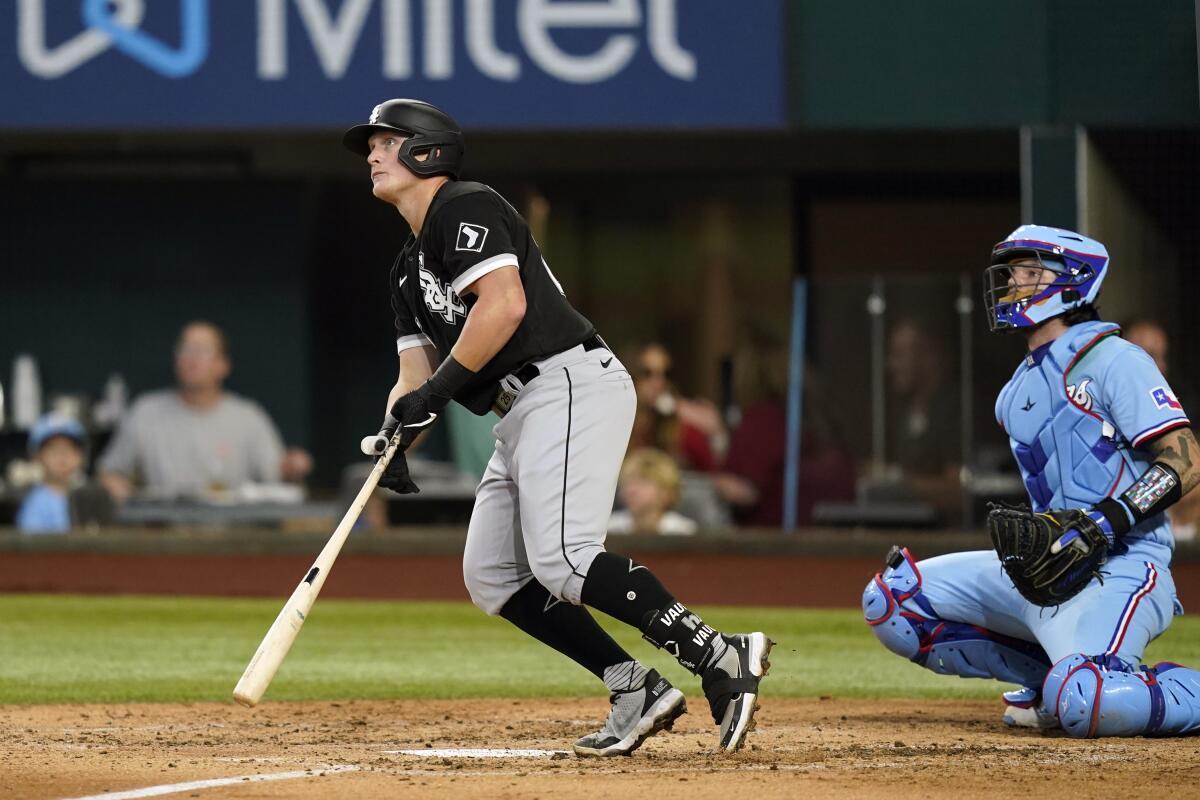 Chicago White Sox's Andrew Vaughn, left, and Texas Rangers catcher Jonah Heim (28) watch Vaughn's two-run home run during the third inning of a baseball game in Arlington, Texas, Sunday, Aug. 7, 2022. White Sox's Jose Abreu also scored on the play. (AP Photo/LM Otero)