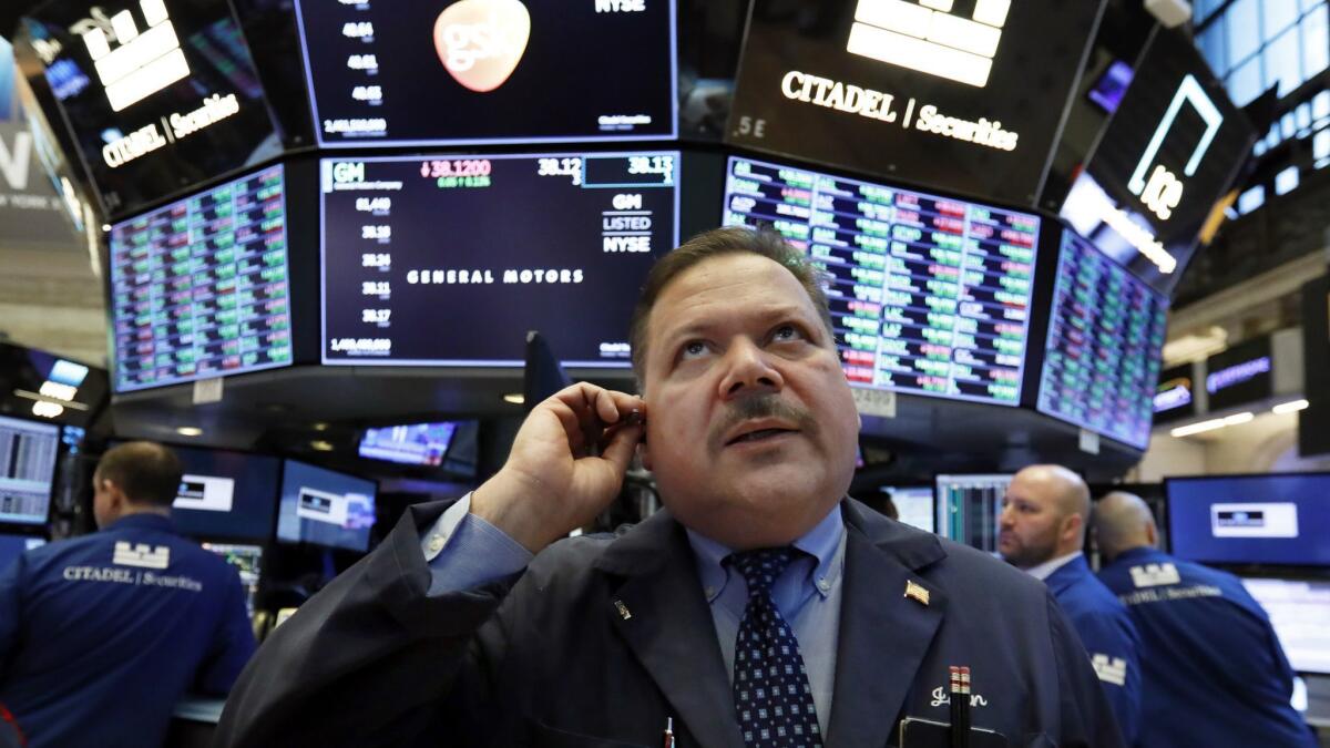 Trader John Santiago works on the floor of the New York Stock Exchange on Monday.
