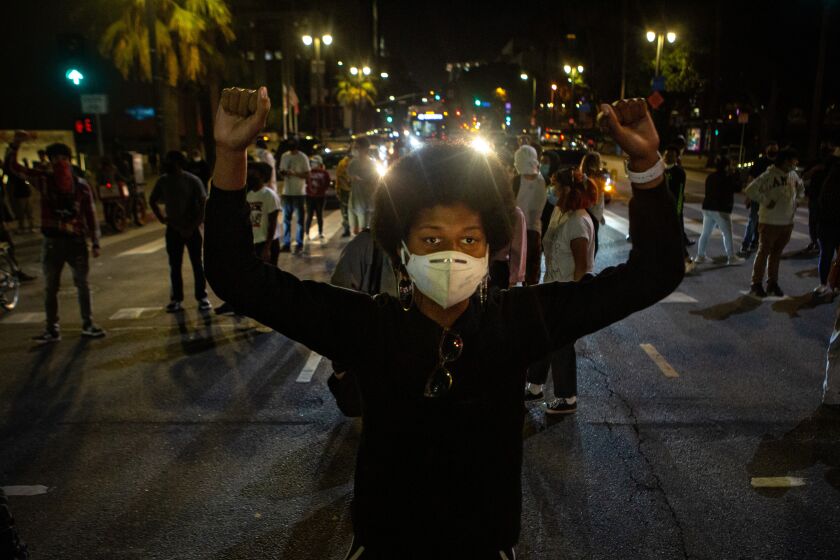 LOS ANGELES, CA - MAY 27: Keni James, 21, of Los Angeles holds both of her fist up in protest as she and other demonstrators block roads in DTLA while protesting the killing of George Floyd in Minnesota by police on Wednesday, May 27, 2020 in Los Angeles, CA. (Jason Armond / Los Angeles Times)