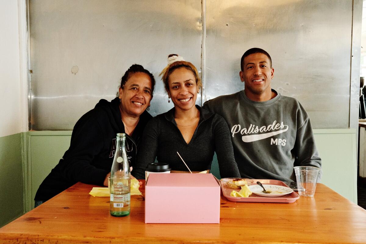 A family sits together at a booth at Cafe Tropical in Silver Lake on reopening day