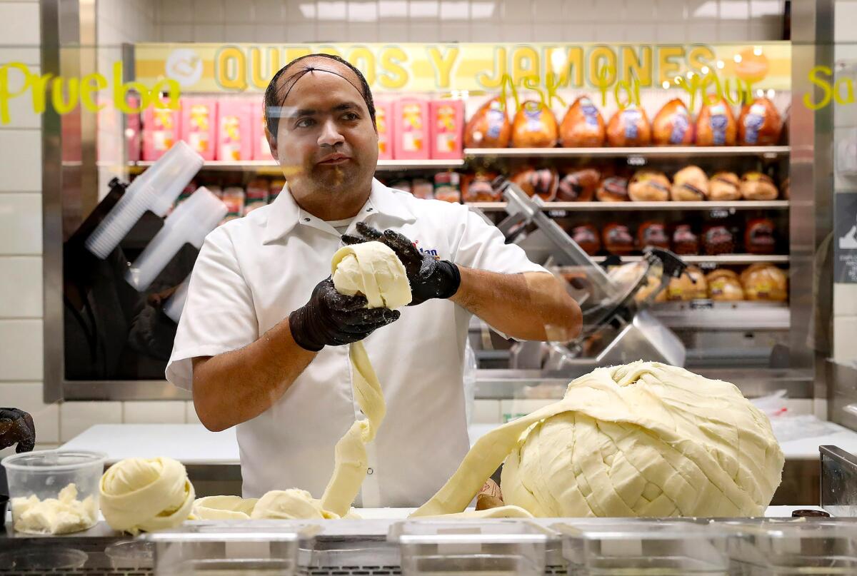Artisan cheese roller Francisco Ochoa wraps a softball-sized piece of Oaxacan cheese.