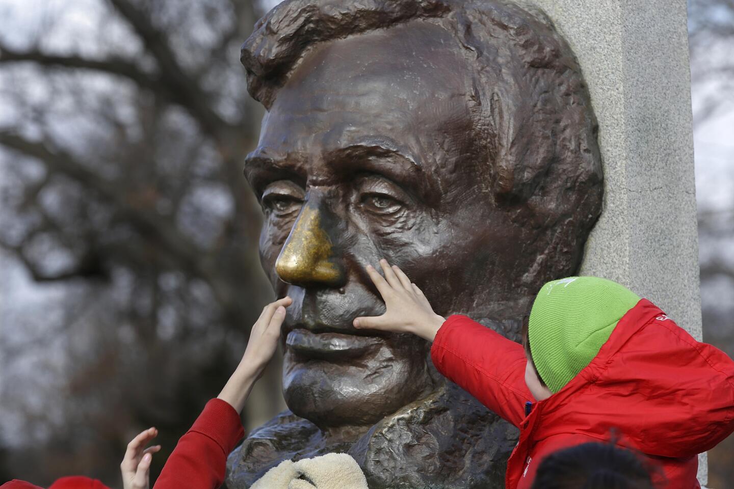 Schoolchildren stretch to rub the nose of Abraham Lincoln for good luck during a ceremony at his tomb in Springfield, Ill., on his birthday, Feb. 12, in 2015.