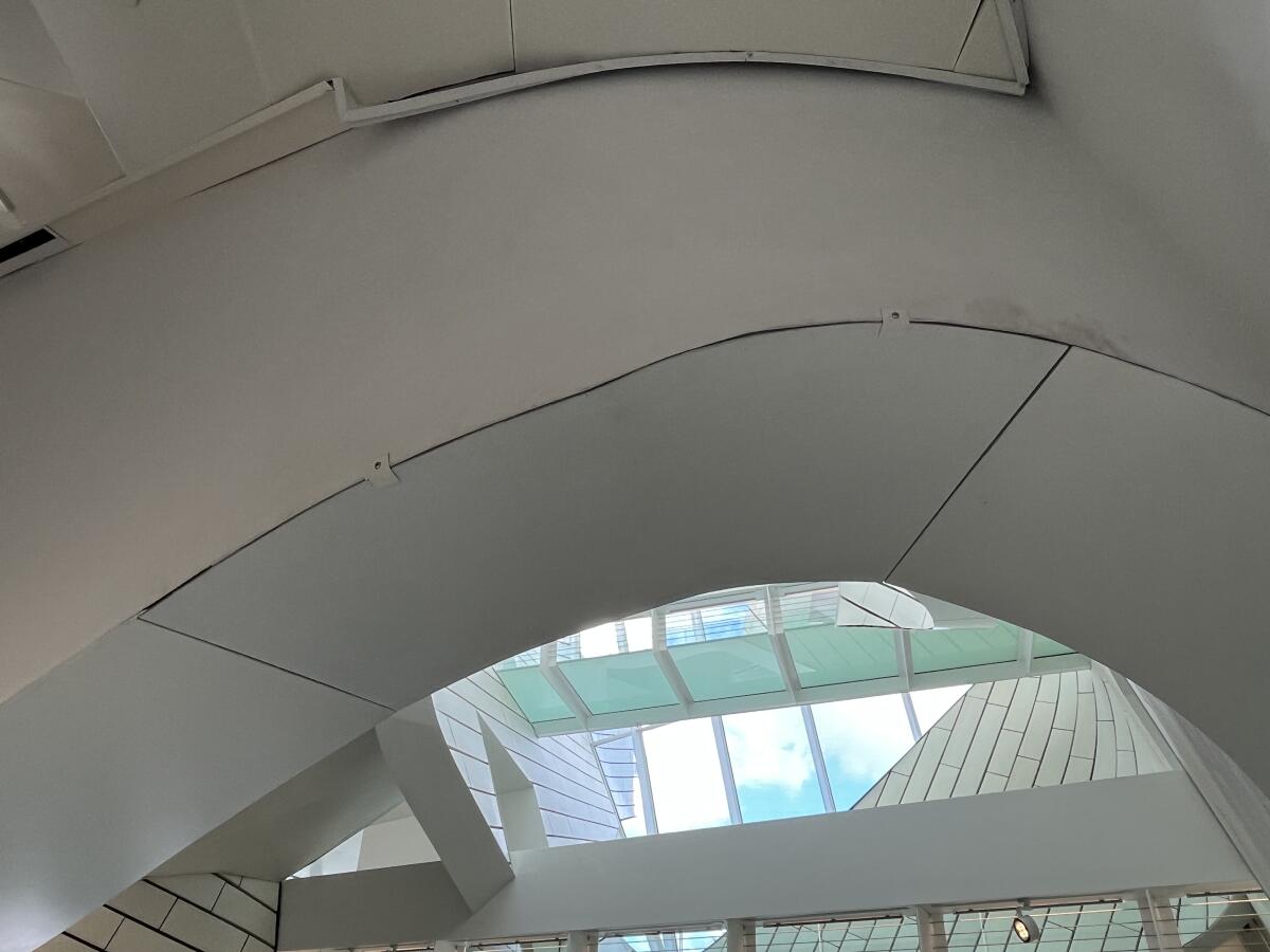 A view of a bend in a ceiling arch reveals misaligned boards clamped together in lieu of steel panels.