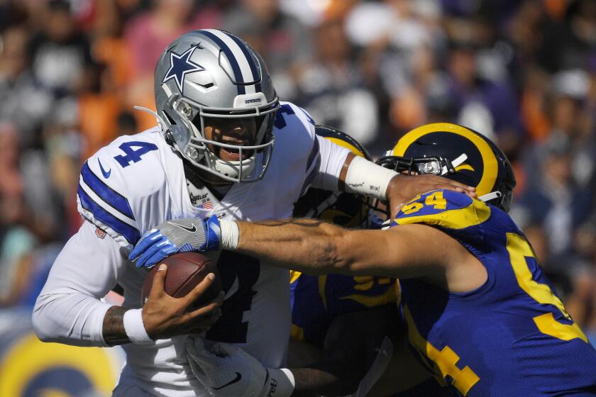 Dallas Cowboys quarterback Dak Prescott, left, is sacked by Los Angeles Rams linebacker Bryce Hager and another defender during the first half of a preseason NFL football game Saturday, Aug. 17, 2019, in Honolulu. (AP Photo/Mark J. Terrill)
