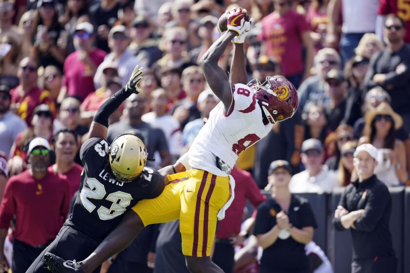 Southern California tight end Michael Trigg, right, pulls in a pass for a touchdown as Colorado safety Isaiah Lewis.