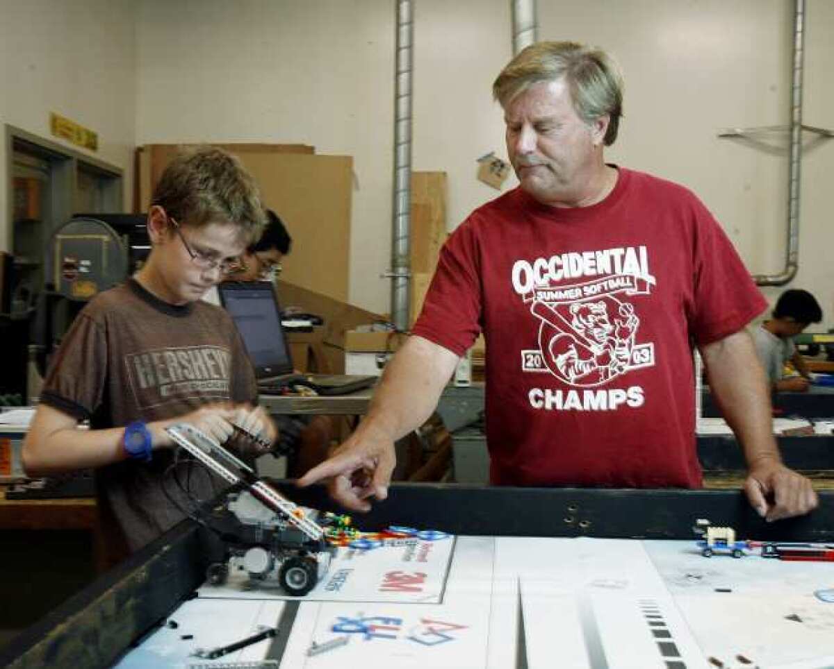 Science teacher Steve Zimmmerman helps Micah Smyth, 11, of Palm Crest Elementary build his team's robot named Spartacus in the engineering lab at La Canada High School on Tuesday, September 25, 2012 with elementary and middle school students preparing robots for an October competition.