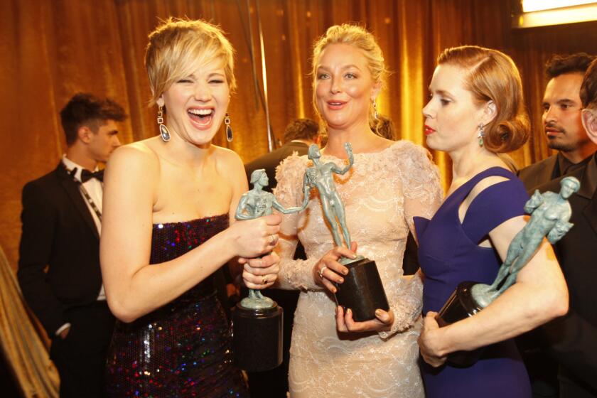 Jennifer Lawrence, left, Elisabeth Rohm and Amy Adams, cast members of "American Hustle," celebrate after winning the award for cast in a motion picture at the 20th Annual Screen Actors Guild Awards at the Shrine Exposition Center in Los Angeles on Jan. 18, 2014.