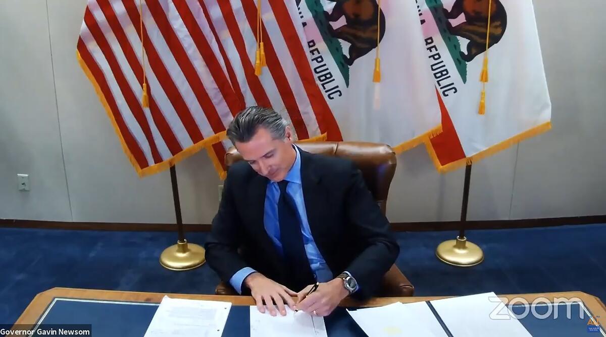 A man signs a document.