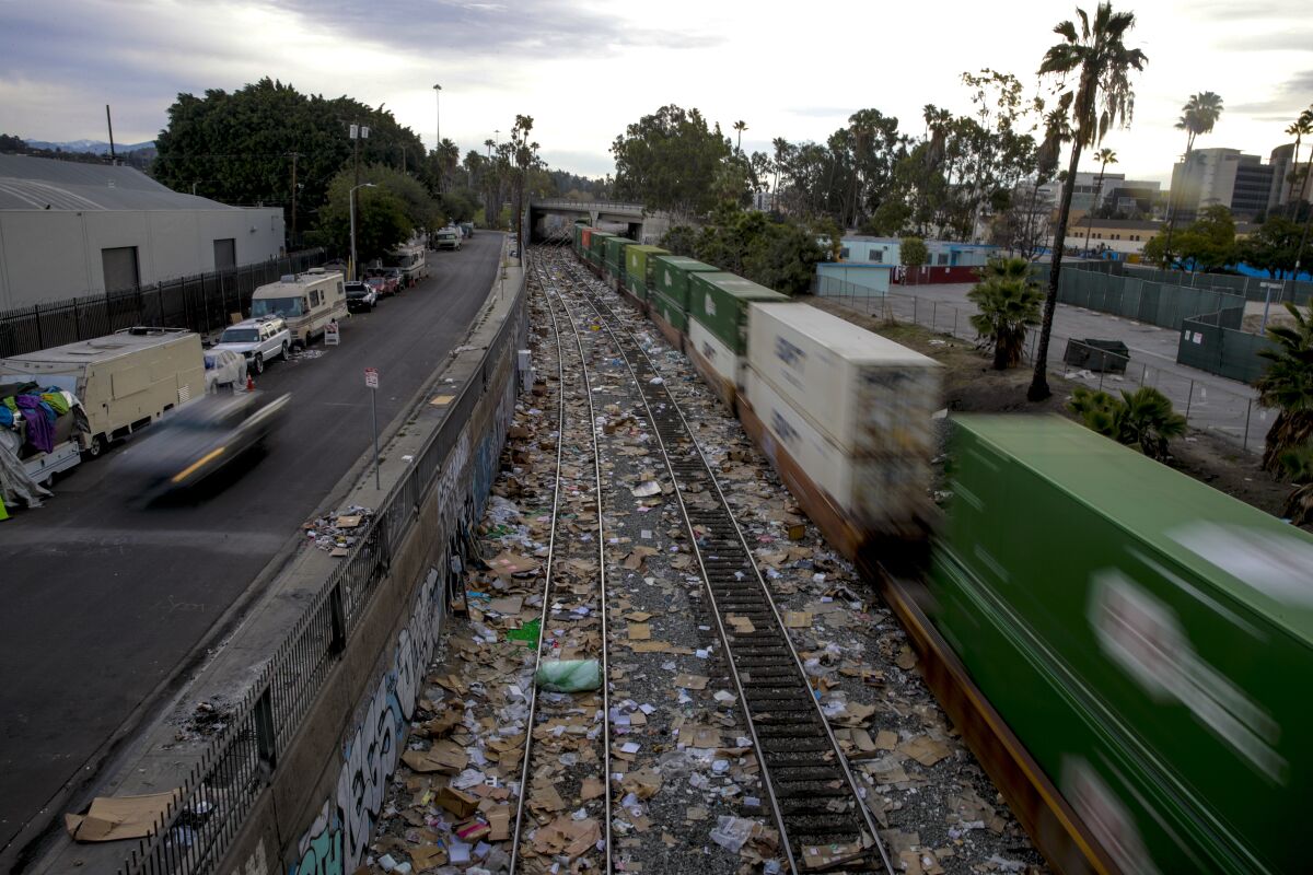 A freight train navigates tracks near downtown Los Angeles that have been littered with thousands of shredded boxes 