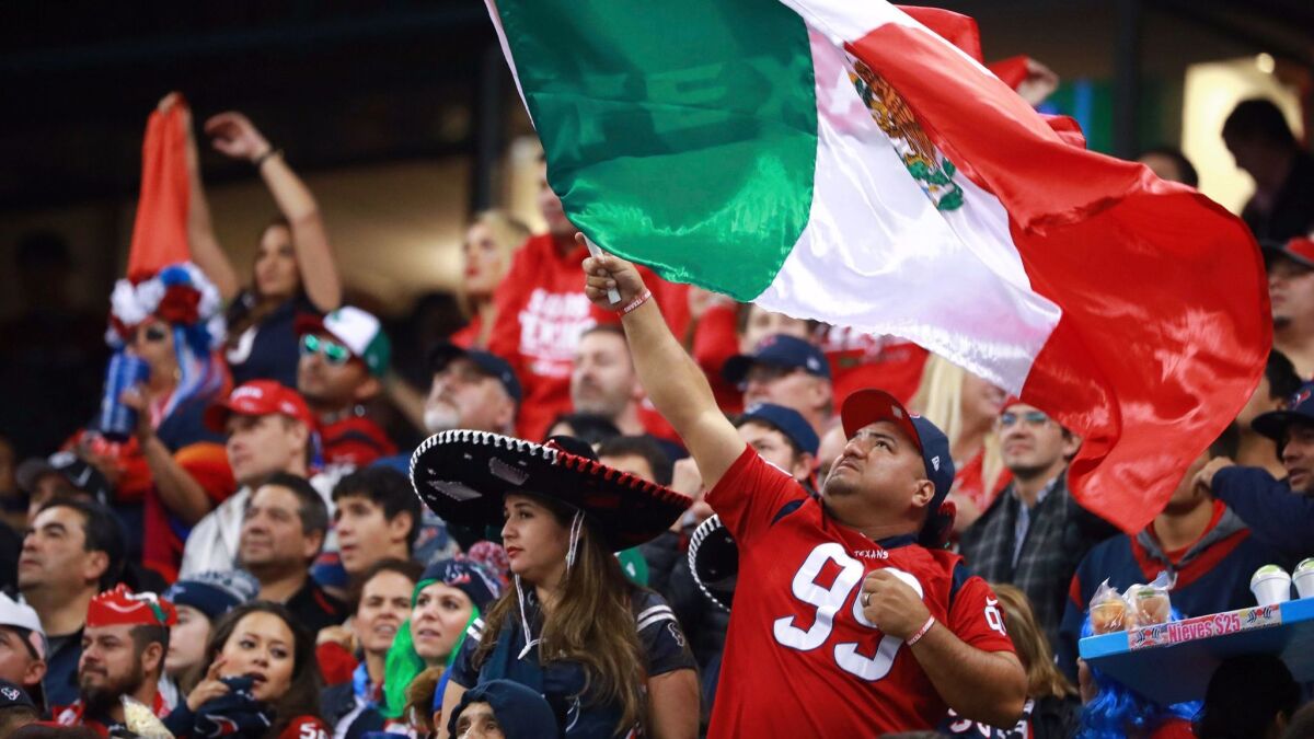 A Houston Texans fan waves a Mexican flag during the 2016 game between the Texans and the Oakland Raiders at Azteca Stadium in Mexico City.