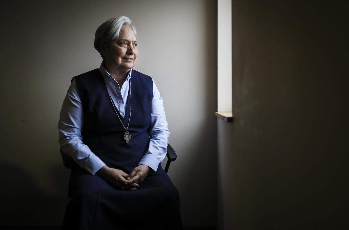 Sister Norma Pimentel sitting in three-quarter profile with hands clasped beside a window