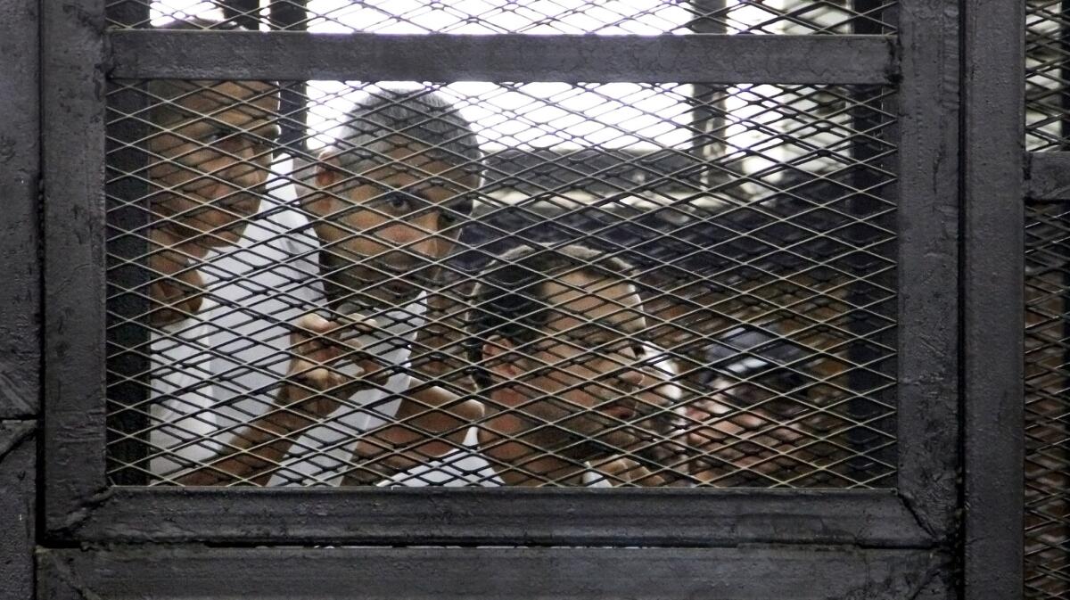 From left, Al Jazeera journalists Peter Greste, Mohamed Fahmy and Baher Mohamed appear in the defendant's cage in an Egyptian courtroom on Monday.
