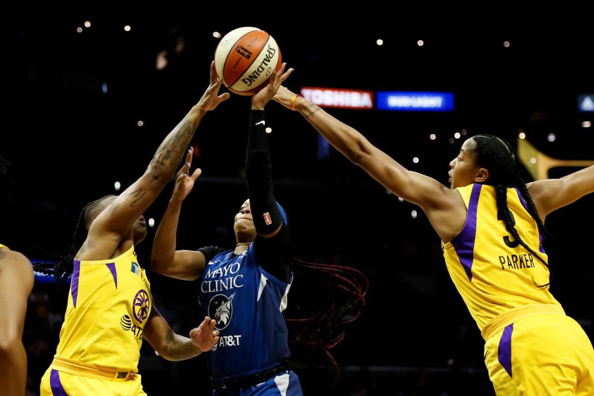 Sparks guard Riquna Williams and forward Candace Parker block a shot by Lynx guard Odyssey Sims during the first half Sunday.