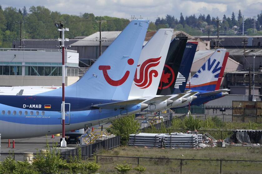 FILE - Boeing 737 Max airplanes, including one belonging to TUI Group, left, sit parked at a storage lot, Monday, April 26, 2021, near Boeing Field in Seattle. Boeing reports earnings on Wednesday, April 24, 2024. (AP Photo/Ted S. Warren, File)