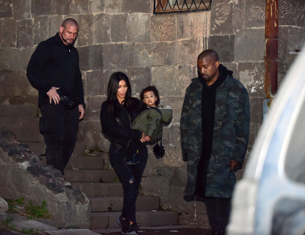 Kim Kardashian holds daughter North in her arms as she and Kanye West walk close to the Geghard Monastery in Armenia.