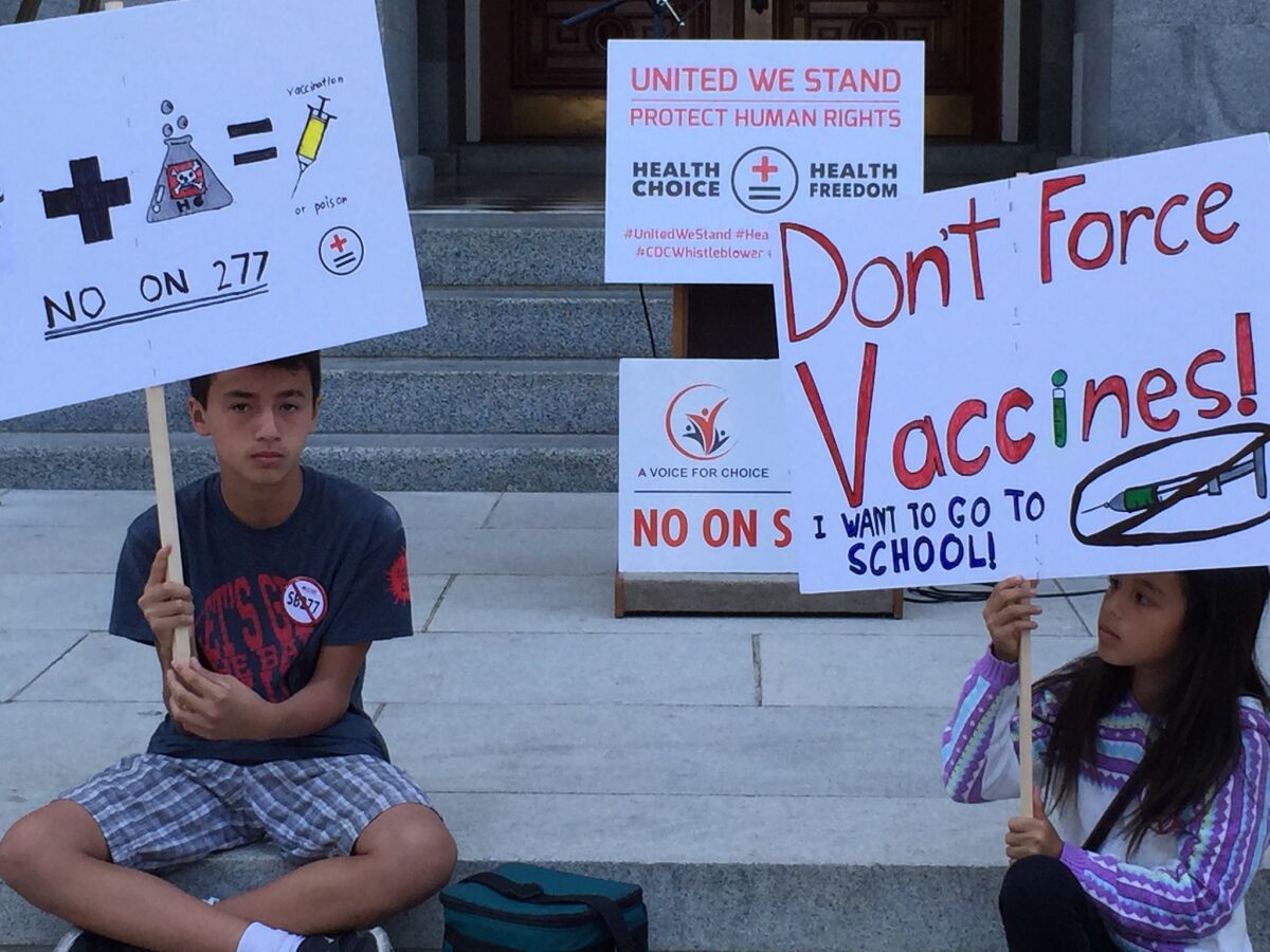 Two children hold up homemade protest signs last week at a rally against legislation that would strengthen California's vaccination mandate. On Monday, state lawmakers sent the bill to Gov. Jerry Brown for approval.