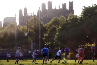 FILE - University of Chicago men's rugby team players practice on the Midway Plaisance near the campus in Chicago, May 6, 2021. The University of Chicago is delaying its new term and holding the first two weeks online. (AP Photo/Shafkat Anowar, File)