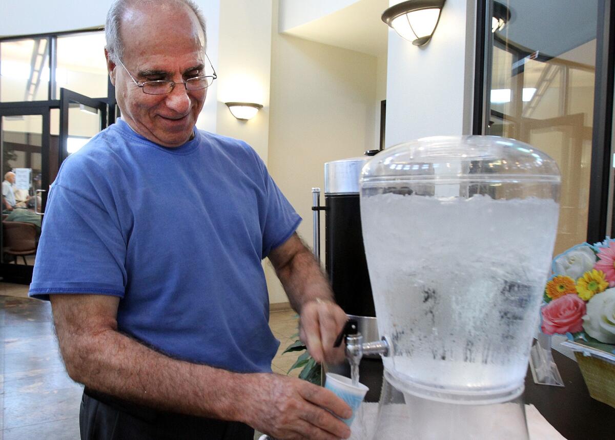 R. B. Bakahsi, of Glendale, fills a cup with ice water at the Adult Recreation Center in Glendale, a cooling station, on Friday, August 30, 2013.