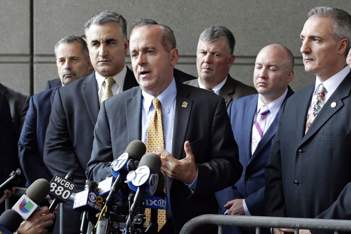 FILE — In this May 31, 2017, file photo, Sgt. Ed Mullins, the head of the Sergeants Benevolent Association, center, speaks to the media outside of the Bronx Supreme Court in the Bronx borough of New York. Federal agents on Tuesday, Oct. 5, 2021, raided the offices of a New York City police union, the Sergeants Benevolent Association, and the Long Island home of its bombastic leader, Ed Mullins, who has clashed repeatedly with city officials over his incendiary tweets and hard-line tactics. (AP Photo/Frank Franklin II, File)