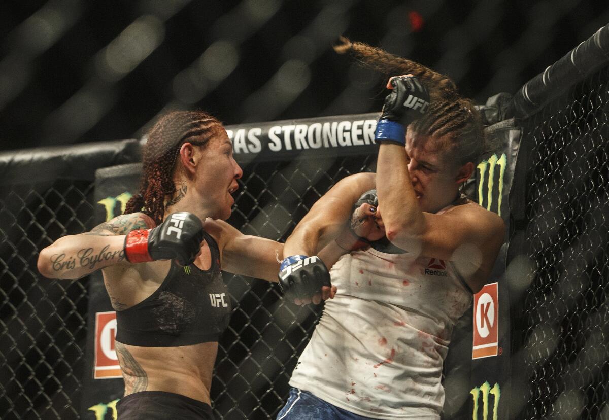 Cris Cyborg, left, hits Felicia Spencer during their bout at UFC 240 on in Edmonton, Alberta.