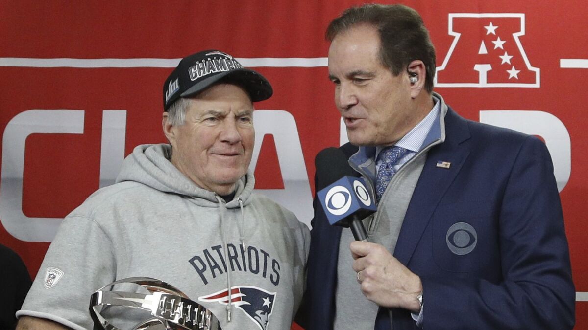 Patriots coach Bill Belichick holds the AFC Championship trophy as he talks with Jim Nantz after beating the Chiefs in the AFC Championship on Sunday in Kansas City.