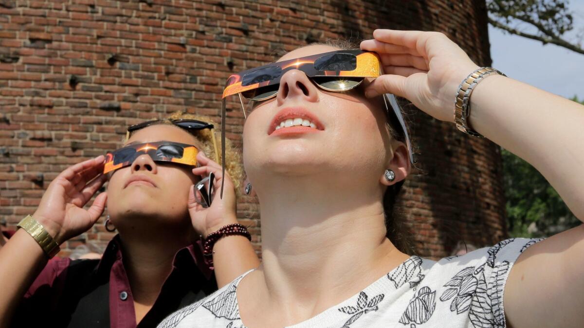 Skywatchers use paper glasses to view the eclipse on the MIT campus in Cambridge, Mass., on Monday. As long as your glasses aren't damaged, they should be OK to use when the next total solar eclipse hits the U.S. in 2024.