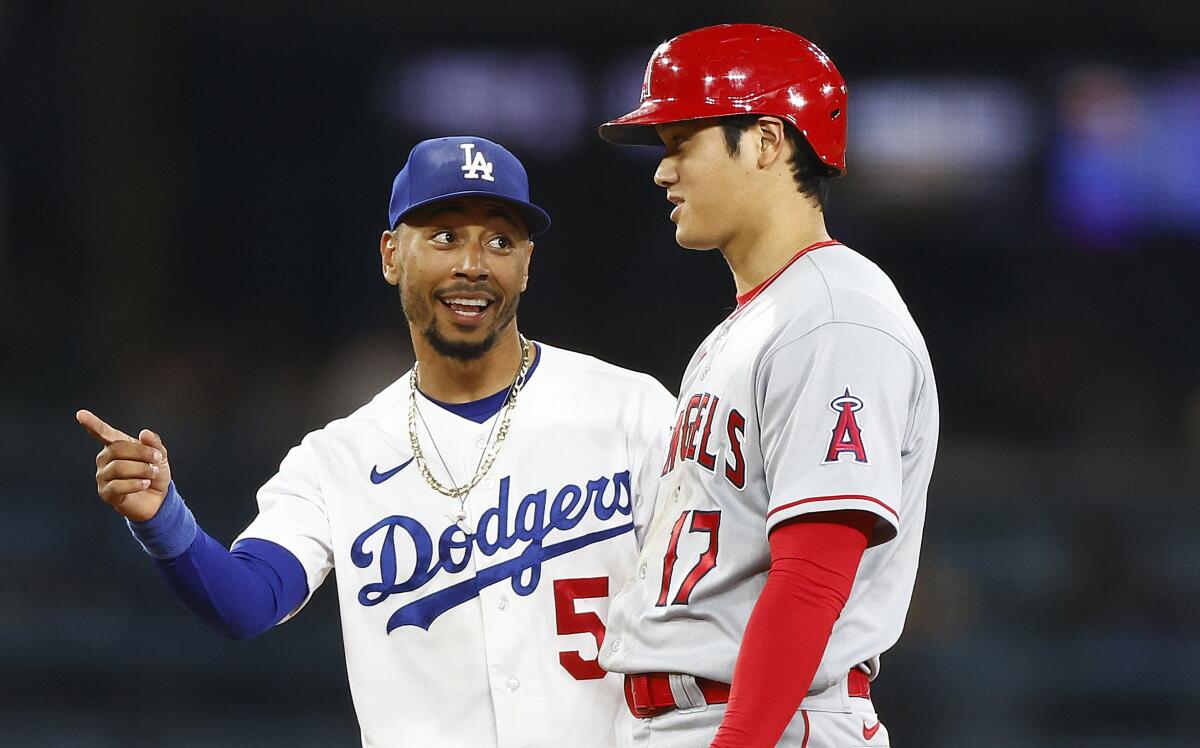 Mookie Betts of the Los Angeles Dodgers talks to the Angels' Shohei Ohtani during a July  2023 game.